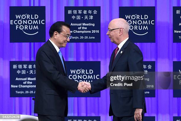 Founder and executive chairman of the WEF Klaus Schwab shakes hands with Chinese Premier Li Keqiang during the World Economic Forum on June 27, 2016...