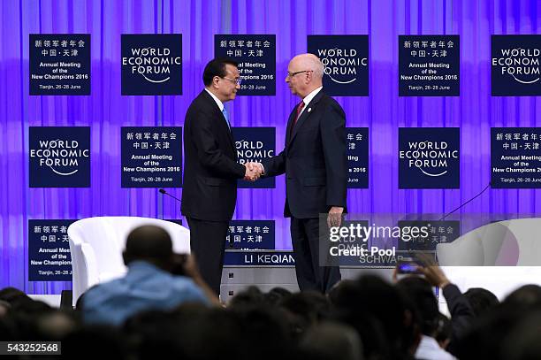 Founder and executive chairman of the WEF Klaus Schwab shakes hands with Chinese Premier Li Keqiang during the World Economic Forum on June 27, 2016...