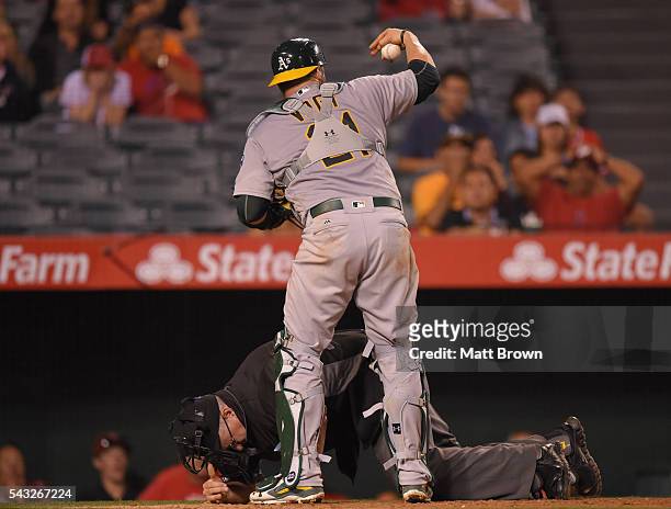 Catcher Stephen Vogt of the Oakland Athletics calls for help as umpire Paul Emmel lies on the ground after being struck in the head with a bat that...
