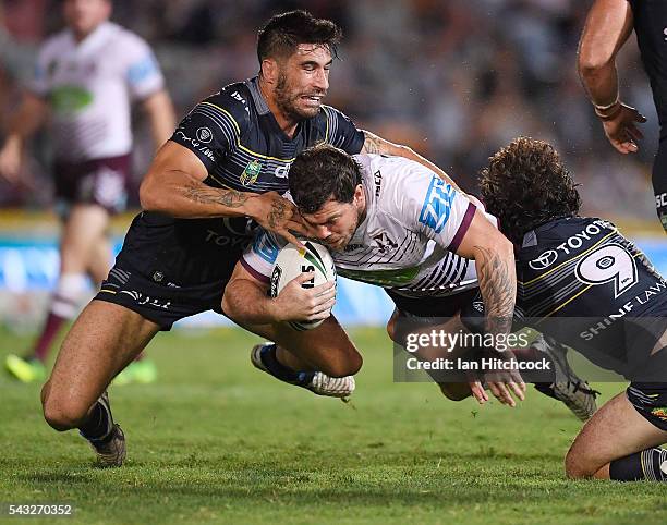 Joshua Starling of the Sea Eagles is tackled by James Tamou and Jake Granville of the Cowboys during the round 16 NRL match between the North...