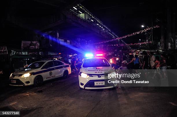 Police patrol a shanty community at night during curfew on June 8, 2016 in Manila, Philippines. The president-elect of the Philippines, Rodrigo...