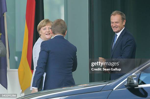 German Chancellor Angela Merkel greets European Council President Donald Tusk and a member of his delegation upon his arrival four days after the...
