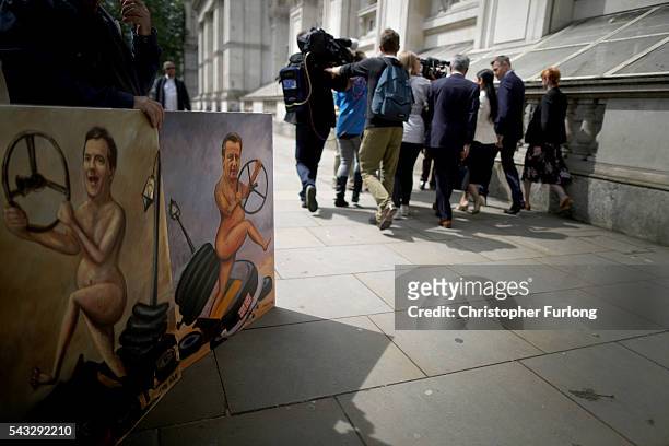 Priti Patel, Minister of State for Employment is pursued by waiting media, past political cartoons of Osborne and Cameron, in Whitehall after a...