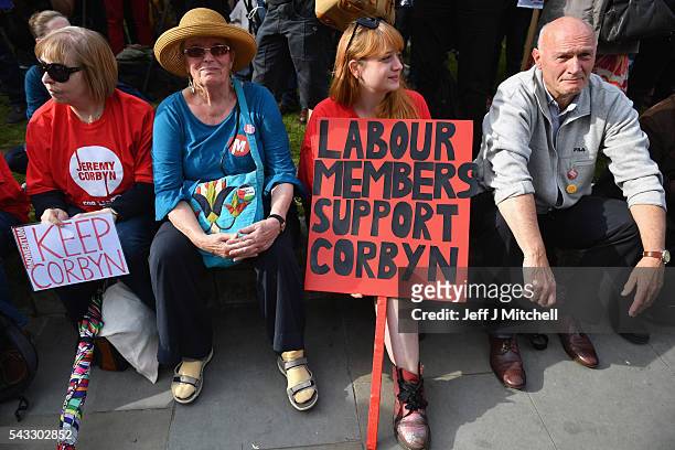 Supporters of Labour leader Jeremy Corbyn hold signs during Momentum's 'Keep Corbyn' rally outside the Houses of Parliament on June 27, 2016 in...