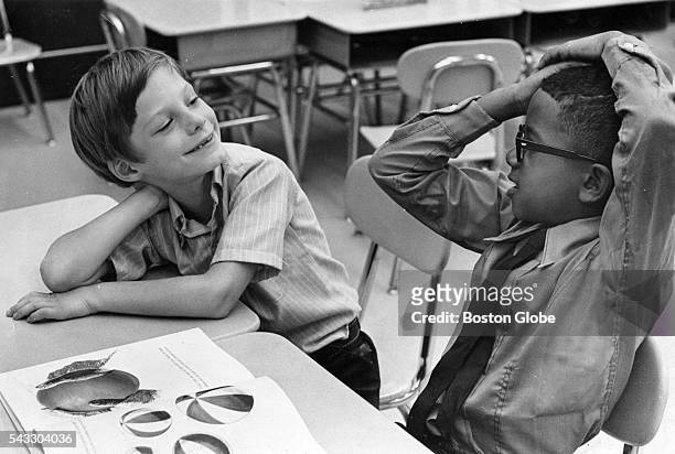 Jim Hard of Framingham, and Joseph Reis of Roxbury, get acquainted on their first day of school at the Trotter School in Boston, Sept. 3, 1969