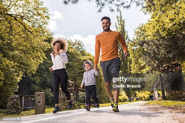happy family having fun while running in the park. - family jogging stock pictures, royalty-free photos & images