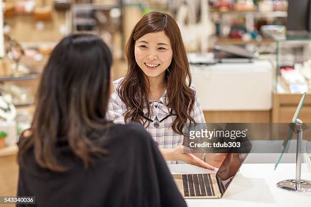 店員のノートパソコンを使用して、顧客をサポート - customer satisfaction ストックフォトと画像