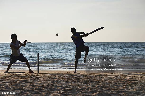 two boys playing cricket on beach, kudle beach, gokarna, india - beach cricket stockfoto's en -beelden