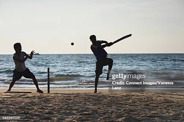 two boys playing cricket on beach, kudle beach, gokarna, india - cricket player silhouette stock pictures, royalty-free photos & images