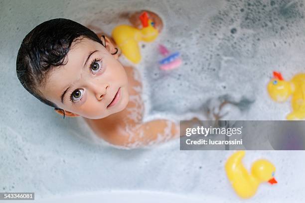 portrait of girl (2-3) bathing with rubber ducks - gummiente stock-fotos und bilder