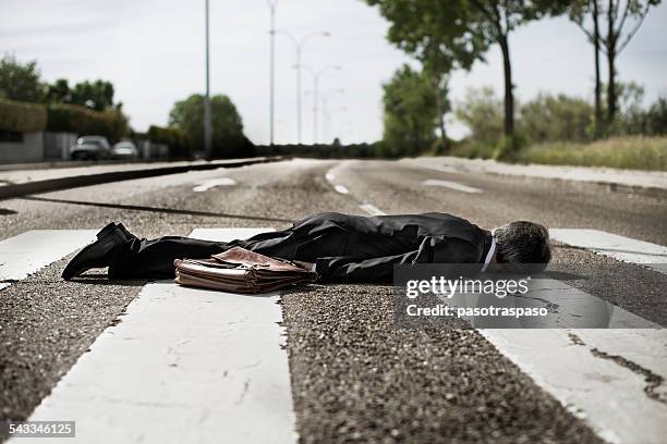 businessman lying on zebra crossing. - unconscious stock-fotos und bilder