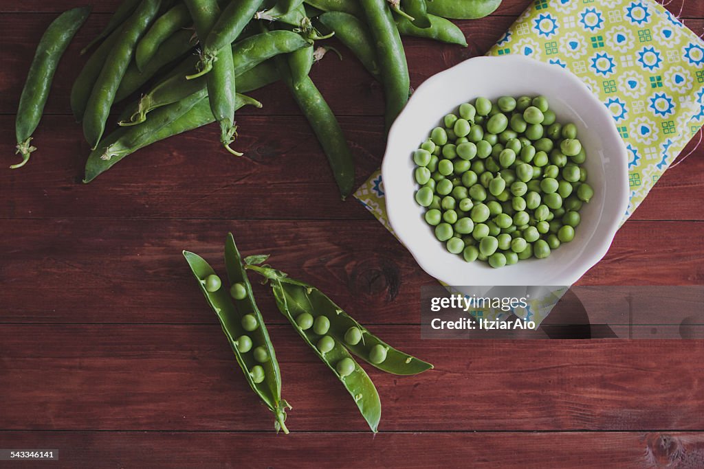 Fresh green peas on wooden table