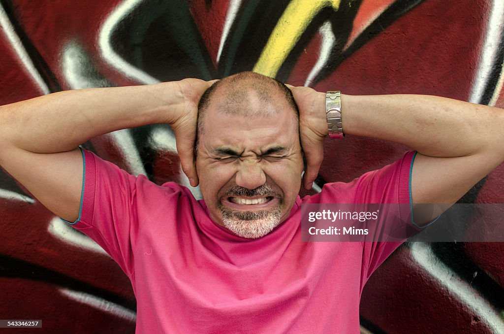 Man frowning and holding head in hands