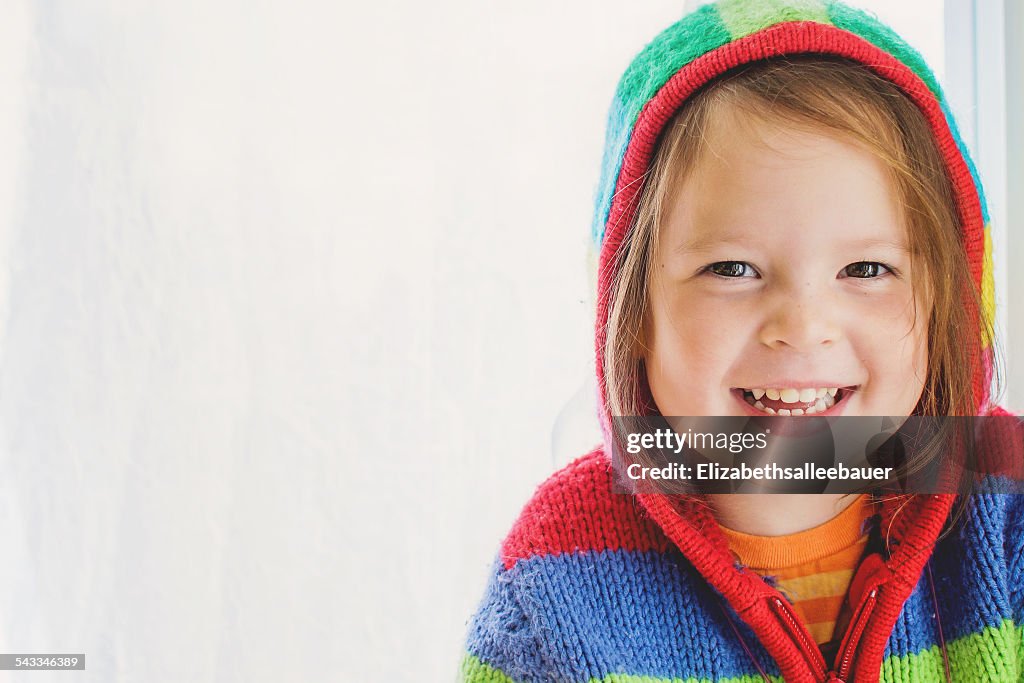 Portrait of  a smiling girl wearing a striped hoodie