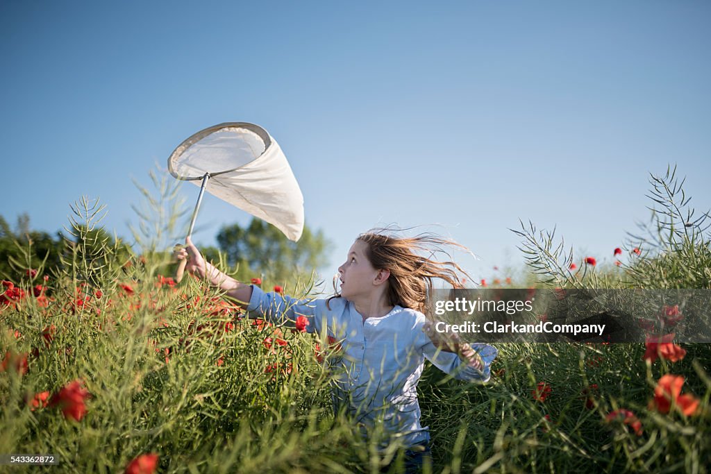 Girl Running Through a Field Trying To Catch Insects