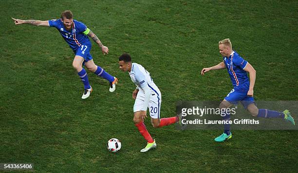 Dele Alli of England competes for the ball against Aron Gunnarsson and Kolbeinn Sigthorsson of Iceland during the UEFA EURO 2016 round of 16 match...