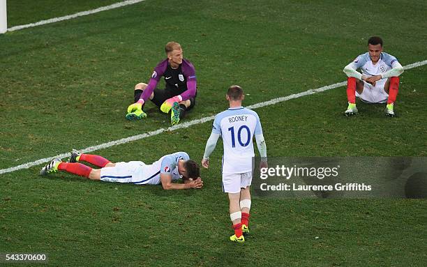 Wayne Rooney of England walks to console Gary Cahill , Joe Hart and Dele Alli after their defeat in the UEFA EURO 2016 round of 16 match between...