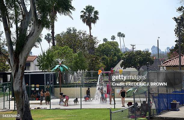 Children cool off at a water park on a hot summer day in Alhambra, east of downtown Los Angeles, California on June 27 where a hot dry heatwave...