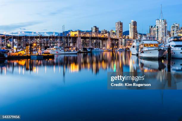 beautiful boats docked at twilight with burrard street bridge in vancouver, canada. - english bay stockfoto's en -beelden