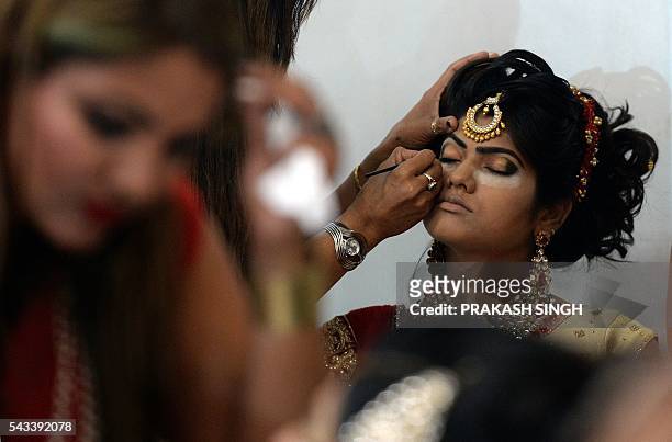 Indian professional make-up artists participate in a bridal make-up competition at the 7th International Beauty and Spa Expo in New Delhi on June 28,...