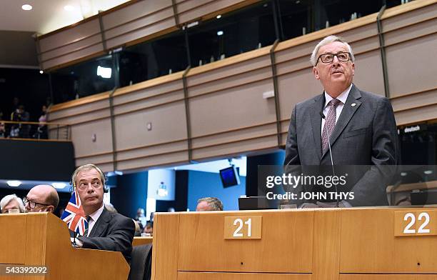 United Kingdom Independence Party leader Nigel Farage looks at European Union Commission President Jean-Claude Juncker as he delivers a speech the...