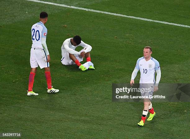 Wayne Rooney of England walks from the pitch as Dele Alli and Daniel Sturridge show their dissapointment after defeat during the UEFA Euro 2016 Round...