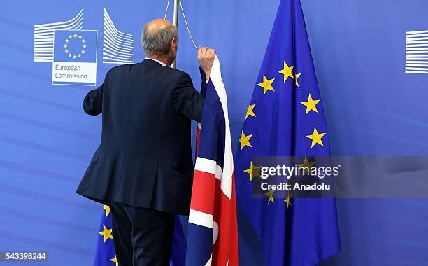 Man hangs the flag of the United Kingdom next to the European Union flag ahead of the meeting between British Prime Minister David Cameron and the...