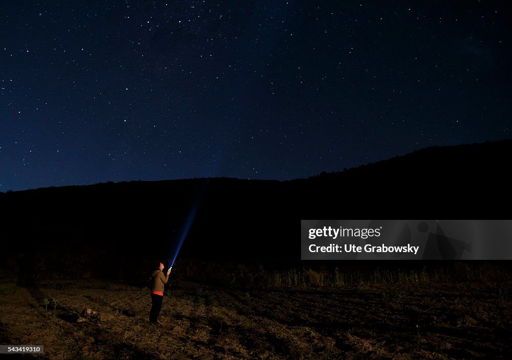 Woman with her torch under the Milky Way in the Andes