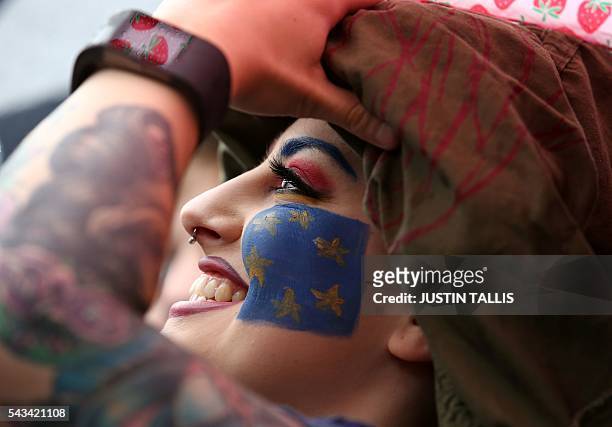 Demonstrator with a European flag painted on her face smiles at an anti-Brexit protest in Trafalgar Square in central London on June 28, 2016. EU...