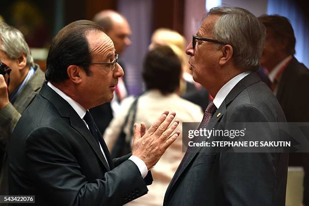 French President François Hollande gestures as he talks with the European Commission President Jean Claude Juncker during EU - Summit at the EU...