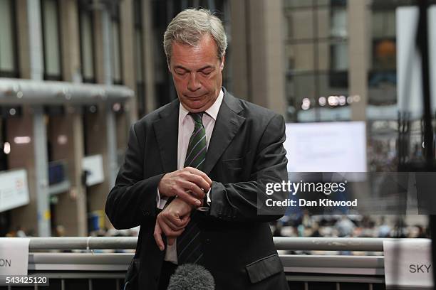 Independence Party leader Nigel Farage checks his watch as he prepares for the media as he attends a European Council Meeting at the Council of the...