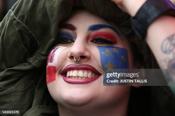 Demonstrator with a European flag painted on her face smiles at an anti-Brexit protest in Trafalgar Square in central London on June 28, 2016. EU...