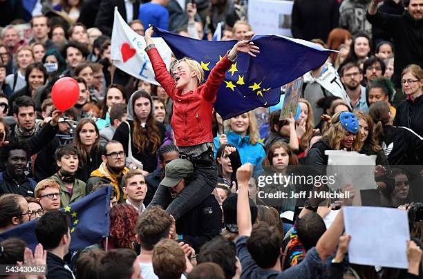 Protesters hold up signs and flags as they demonstrate against the EU referendum result outside the Houses of Parliament on June 28, 2016 in London,...