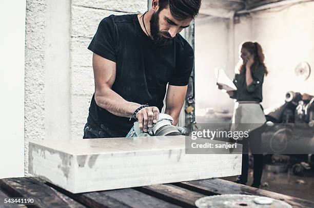 stonecutter at his workshop - man cutting wire stockfoto's en -beelden