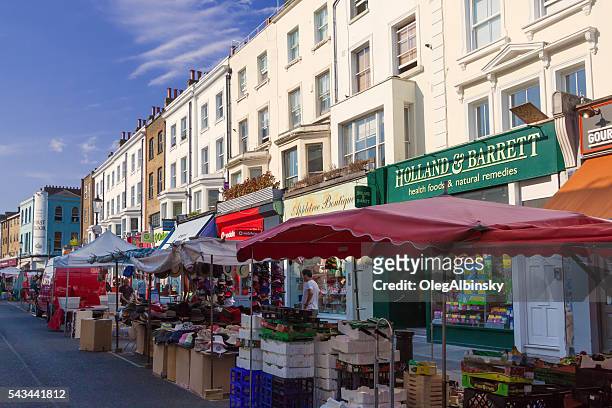 portobello road market lined with stores, notting hill, london, england. - portobello stock pictures, royalty-free photos & images