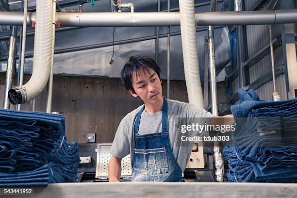 textile industry worker checking inventory with digital tablet before shipping - textile worker stock pictures, royalty-free photos & images