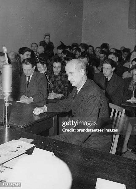 German conductor Wilhelm Furtwängler before the Denazification Board during his examination. Behind him are reporters. Germany. Photograph. 1946.