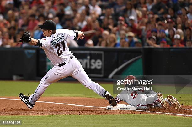 Odubel Herrera of the Philadelphia Phillies safely slides into first base as Zack Greinke of the Arizona Diamondbacks stretches to make a play on a...