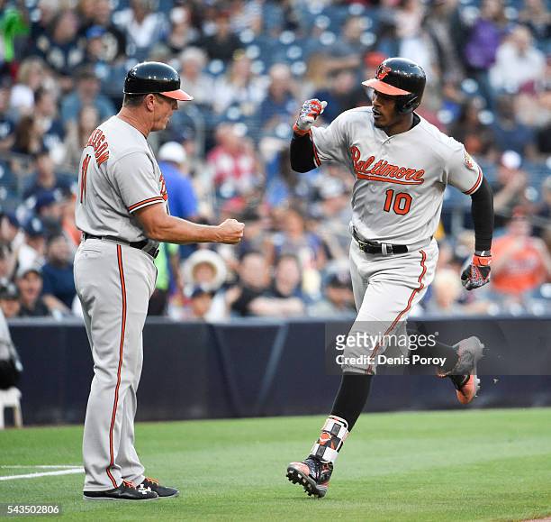 Adam Jones of the Baltimore Orioles, right, is congratulated by Bobby Dickerson after hitting a solo home run during the first inning of a baseball...