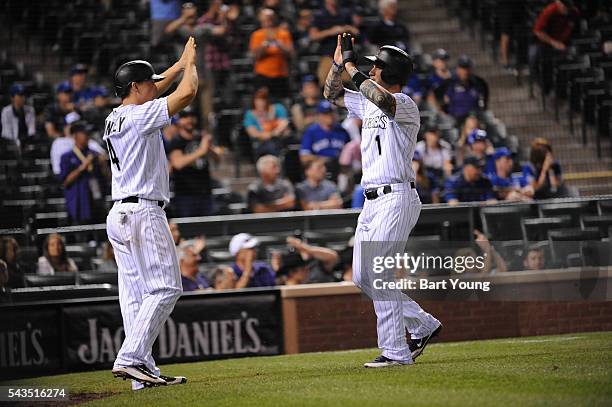 Nick Hundley and Brandon Barnes of the Colorado Rockies celebrate their runs in the seventh inning against the Toronto Blue Jays at Coors Field on...