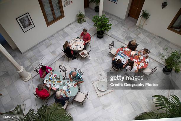 Historic building interior, Hotel Casa Grande, Jerez de la Frontera, Spain looking down courtyard people eating breakfast.