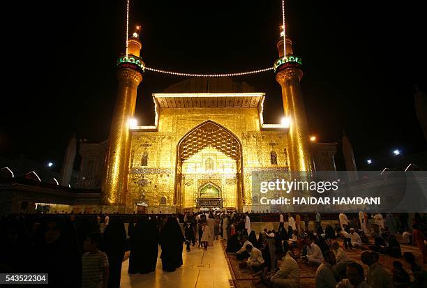 Shiite Muslims pray on Laylat al-Qadr which marks the night in which the holy Koran was first revealed to the Prophet Mohammed, outside the shrine of...