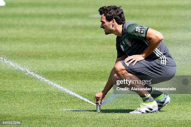 Mats Hummels of Germany plays with the automatic water sprinkler on the field during a Germany training session at Ermitage Evian on June 29, 2016 in...