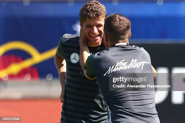 Lukas Podolski of Germany jokes with his team mate Thomas Mueller during a Germany training session at Ermitage Evian on June 29, 2016 in...