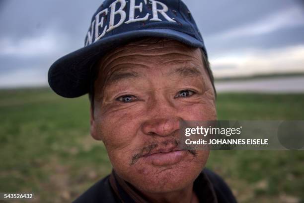 This picture taken on June 29, 2016 shows herder Zandraagiin Budjav, who works with herder Pagvajaviin Shatarbaatar, posing for a picture in the Gobi...