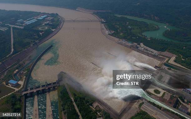 This aerial view shows water being released from the floodgates of the Xiaolangdi dam on the Yellow River near Luoyang, in China's Henan province on...