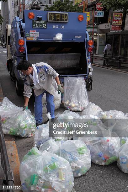 Japan Tokyo Ikebukuro garbage collection collector Asian man truck compactor plastic bags empty bottles recycling.