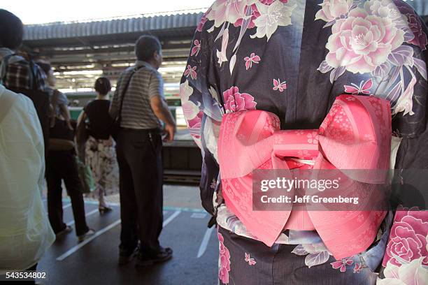 Japan Tokyo Akihabara Station platform train subway Yukawa kimono traditional robe obi sash tied Asian woman commuters.