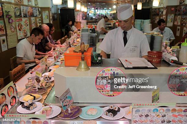 Japan Tokyo Tsukiji Fish Market kanji hiragana characters sushi bar restaurant moving dishes priced customers eating dining Asia.