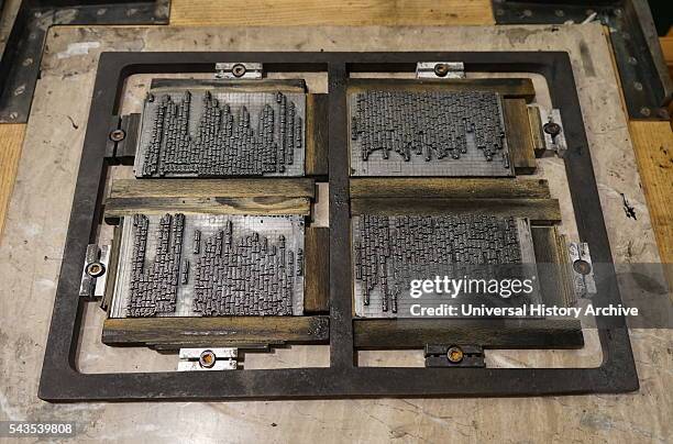 Metal plate with letters set to print a page from a reconstruction of a 16th Century printing press.